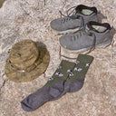 Flatlay van hiking items en koeienmotief op merinowollen Alfredo Gonzales sokken.