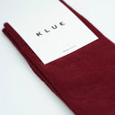 Flatlay van bordeauxrode KLUE sokken van biologisch katoen, ademende textuur met stijlvolle uitstraling.