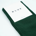 Flatlay van groene KLUE sokken van biologisch katoen, elegante textuur met soepele afwerking.