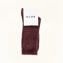 Flatlay van bordeauxrode KLUE sokken met label, zijde en wol combinatie met duurzame textuur en elegant design.