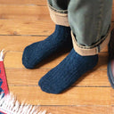 Model draagt blauwe KLUE sokken van zijde en wol, elegante glans met comfortabele pasvorm en luxe uitstraling.