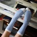 Model draagt blauw-witte KLUE sokken van merinowol, stijlvolle pasvorm met zachte en ademende structuur.