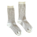 Flatlay van grijs-witte KLUE sokken van merinowol, duurzame textuur met subtiele afwerking.